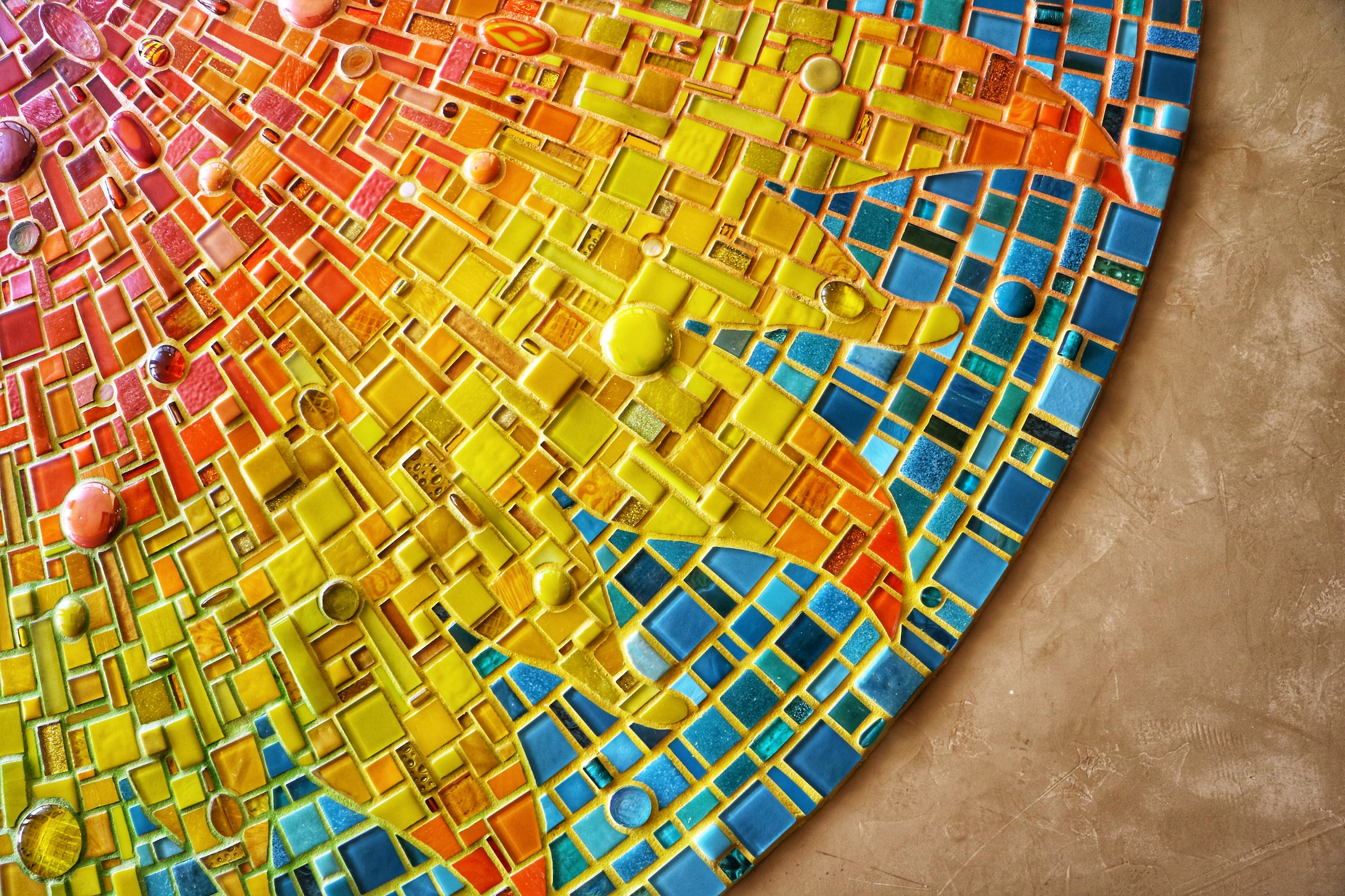 Ausschnitt eines bunten Mosaiks, dass eine Sonne zeigt